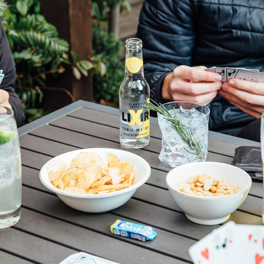 herbal gin and tonic with snacks on table